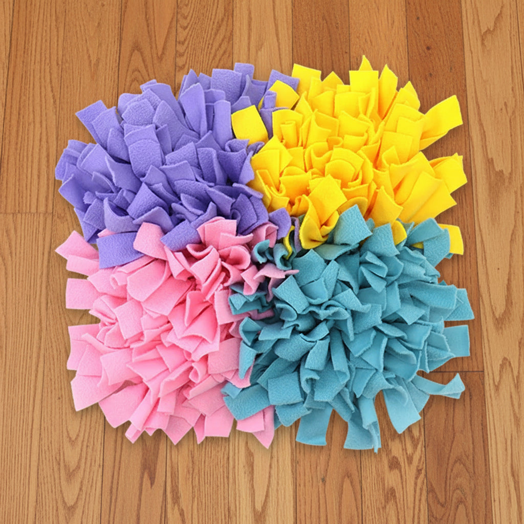 A colorful snuffle mat with purple, yellow, pink, and green corners, on a wood floor