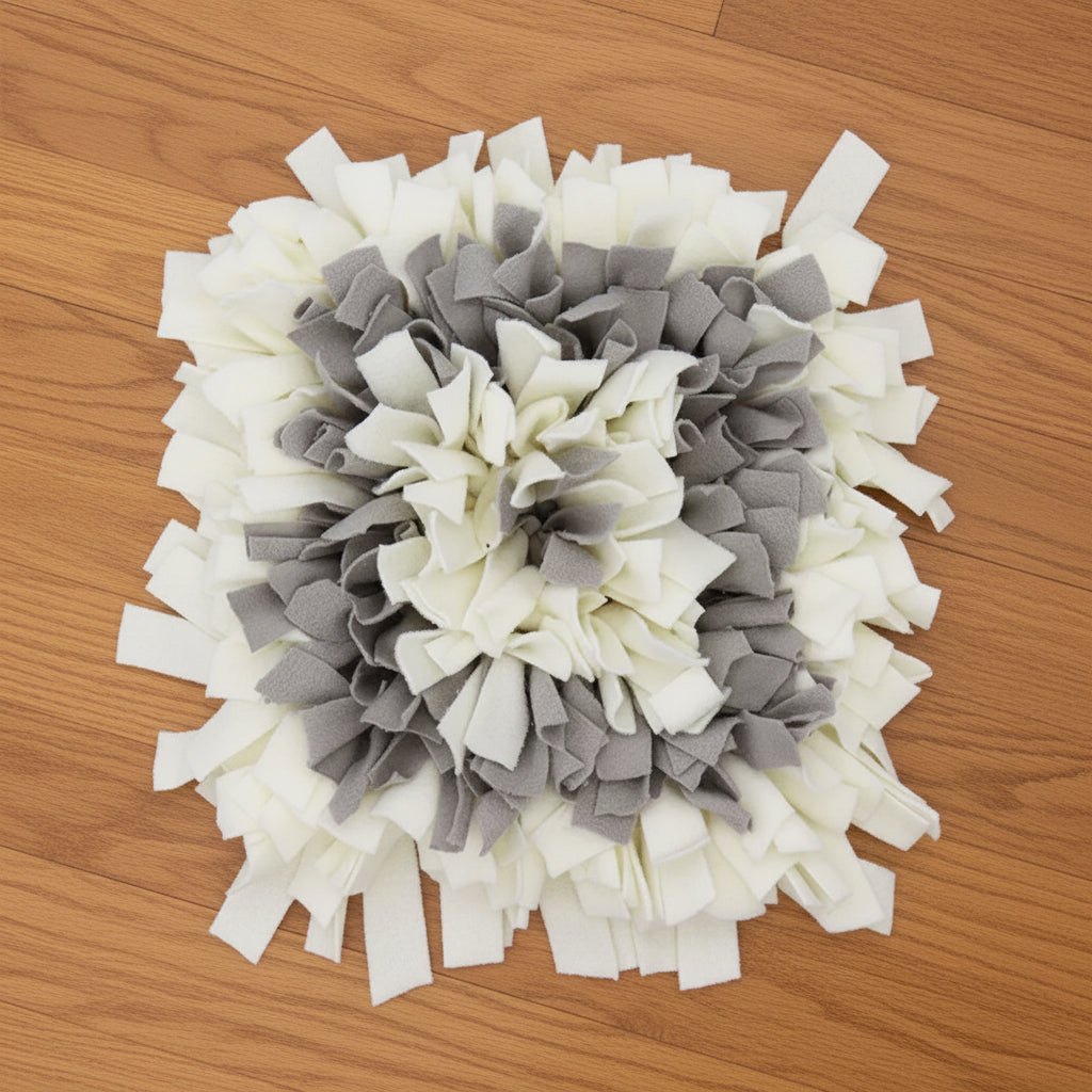 A gray and white snuffle mat on wood floor