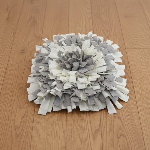 Gray and white snuffle mat on a wood floor