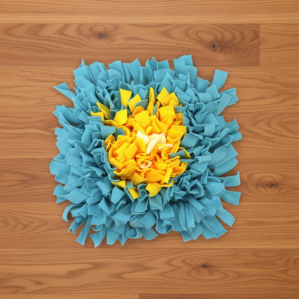 Square snuffle mat with blue edges and yellow center on a hardwood floor
