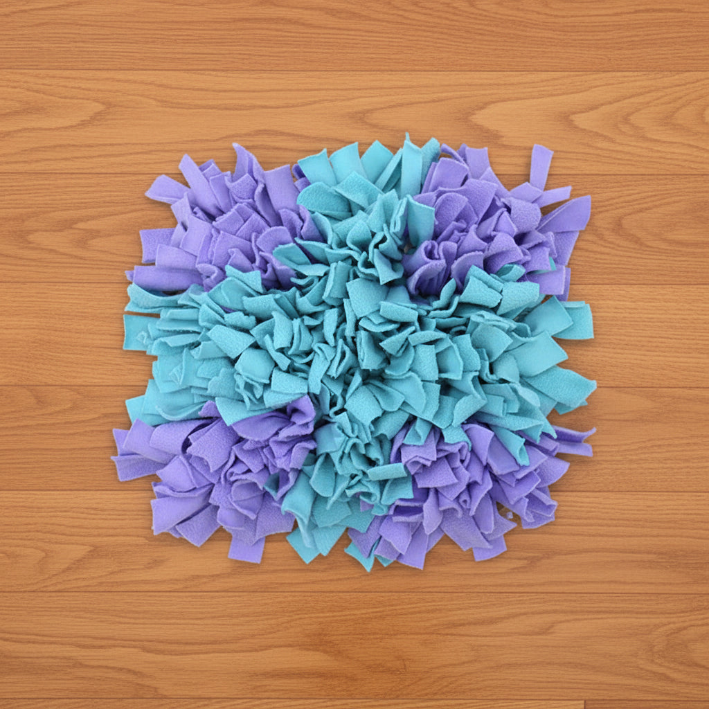 Turquoise and purple snuffle mat for pets on a wood floor