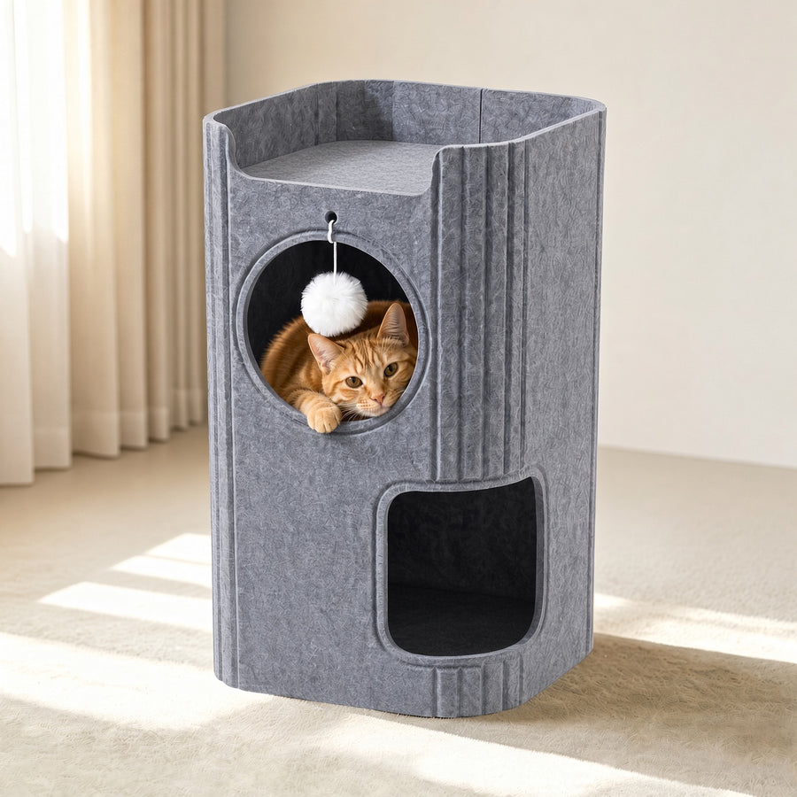A gray felt cat tower with multiple levels and openings, shown in a sunlit room with an orange tabby cat peeking out from the circular upper compartment.