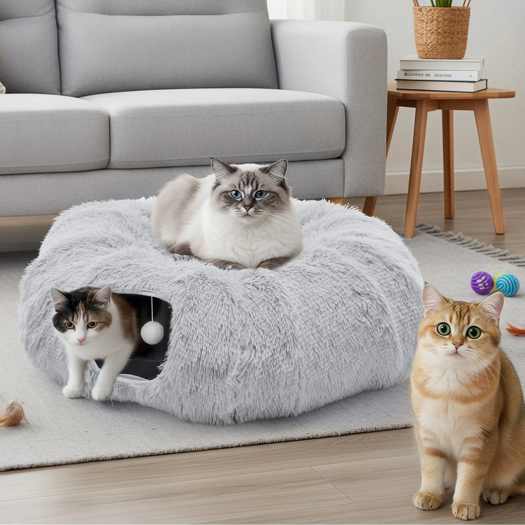 3 cats using the Donut Cat Tunnel Bed, one is laying in the bed on top, one is exiting the tunnel, the other is sitting outside