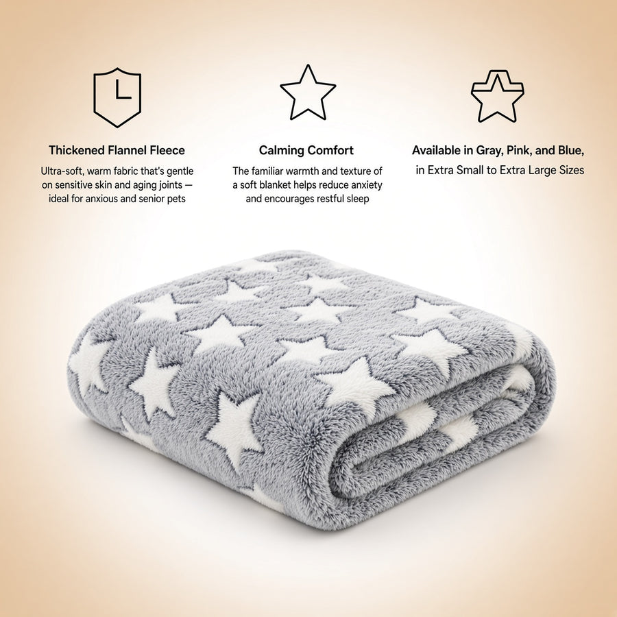 A folded gray plush pet anxiety blanket with white star patterns is shown on a warm beige gradient background with three informational text callouts above it. The text highlights thickened flannel fleece, calming comfort, and available colors including gray, pink, and blue.