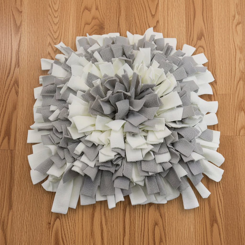Gray and white snuffle mat on a wood floor