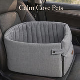 A video of a gray fabric pet car bed with a zippered side and padded rim, shown placed on a car seat. The text 'Calm Cove Pets' appears at the top.
